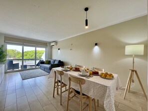 A dining area with a table set for breakfast, a sofa, and a view of the outdoors. - Vilamoura Charming 3 With Pool by Homing (Loulé)