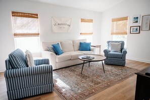 A living room with a sofa, armchairs, a coffee table, and a patterned rug. - Bright and Cozy St. Augustine Home near Downtown (St. Augustine)