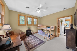 A room with a bunk bed, a desk with a lamp, a sofa, and a large window. - Oquaga Lakefront | Dock, Kayaks & Sunsets (Deposit)