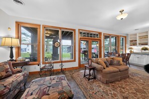 A spacious living room with a large window, a fireplace, and a cozy seating area.