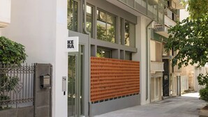Un edificio moderno con una amplia fachada de vidrio, una puerta metálica y un letrero que dice 'KEA'.