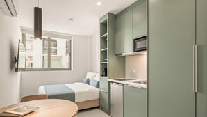 A compact kitchen with a microwave, a dishwasher, and a small dining area with a table and chairs.