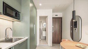 A modern kitchen with a microwave, sink, and a dining area with a table and chairs.