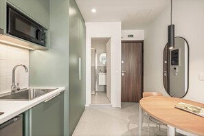 Une cuisine moderne équipée d’un four à micro-ondes, d’un évier et d’un coin repas avec une table et des chaises.