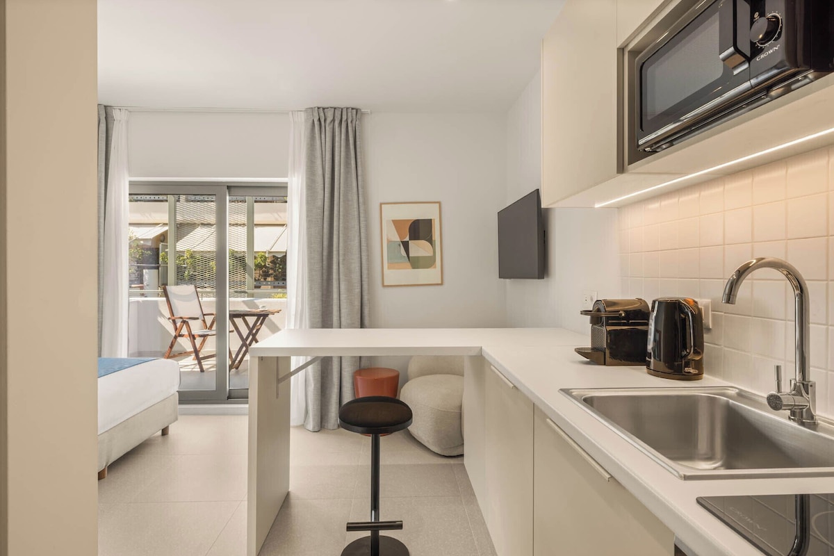 Cozinha compacta equipada com micro-ondas, torradeira e pia.