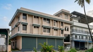 A multi-story residential building with a flat roof, balconies, and a garage. - Hotel Aiden Residency Aluva (North Paravur)