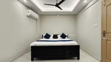 Un dormitorio con cama, ventilador de techo y aire acondicionado.
