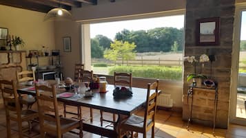 Un comedor con una mesa grande, sillas y vistas al exterior.