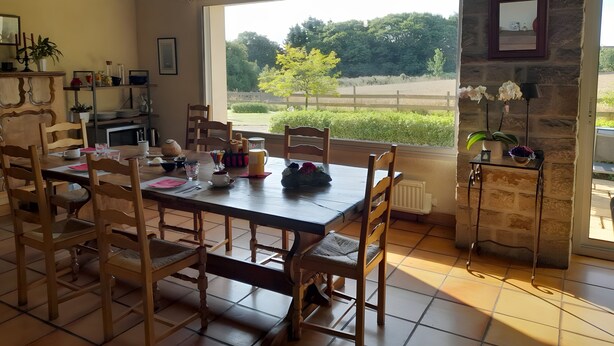 Un comedor con una mesa grande, sillas y vistas al exterior.