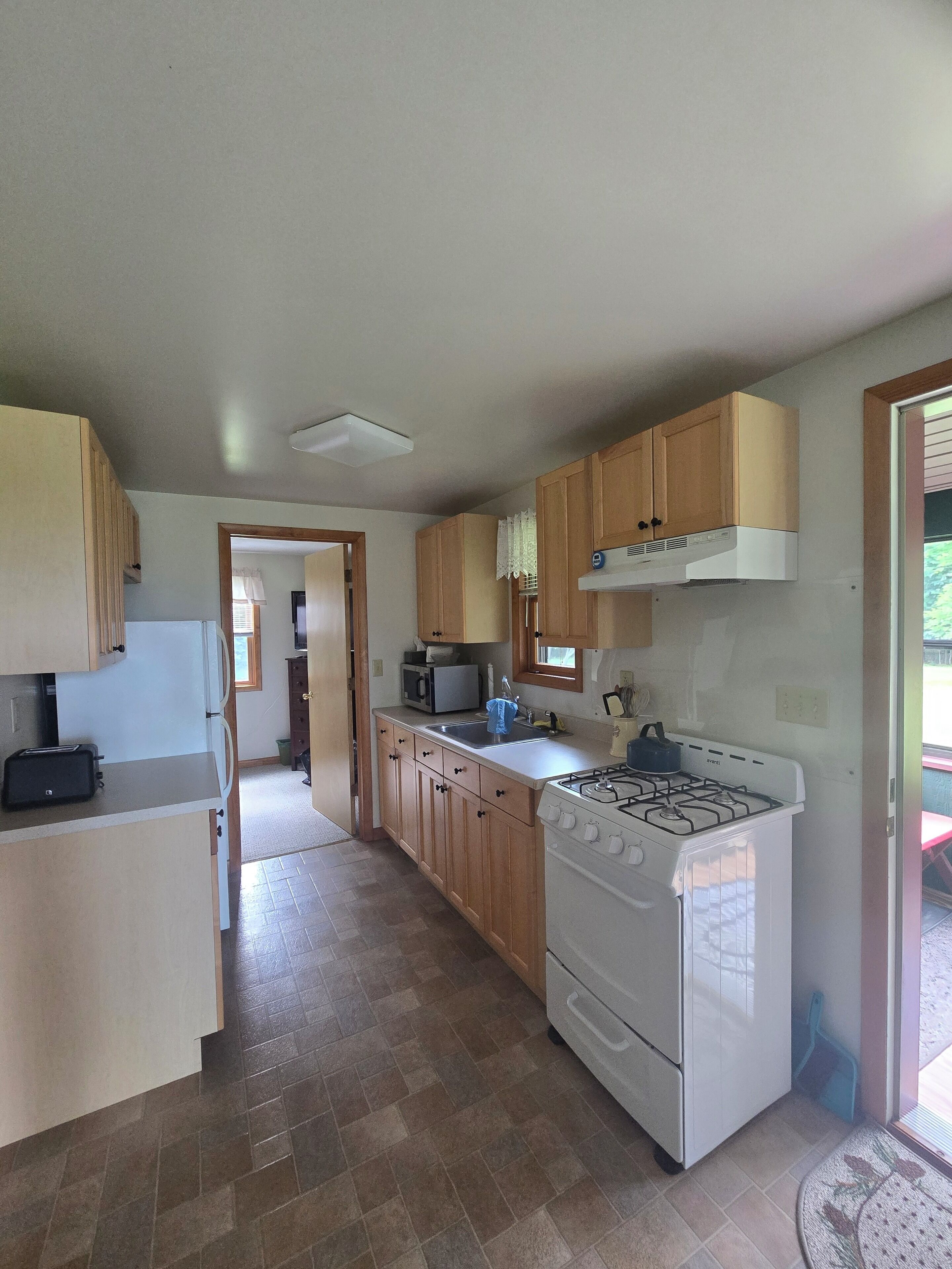A kitchen with wooden cabinets, a stove, a microwave, and a toaster.
