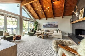 A spacious living room with a high ceiling, large windows, and a fireplace. - Designer Pinnacle Home with Free DV Shuttle (Park City)