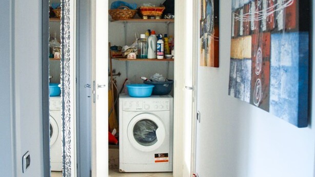 A hallway with a washing machine, a mirror, and a painting on the wall. - Family-friendly vacation home just a 5-minute walk from the beach (Civitanova Marche)