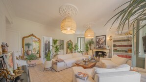 A spacious living room with a fireplace, white sofas, and a coffee table. - Bed and Breakfast 'Chambre 1' with Shared Pool, Wi-Fi and Air Conditioning (La Motte)