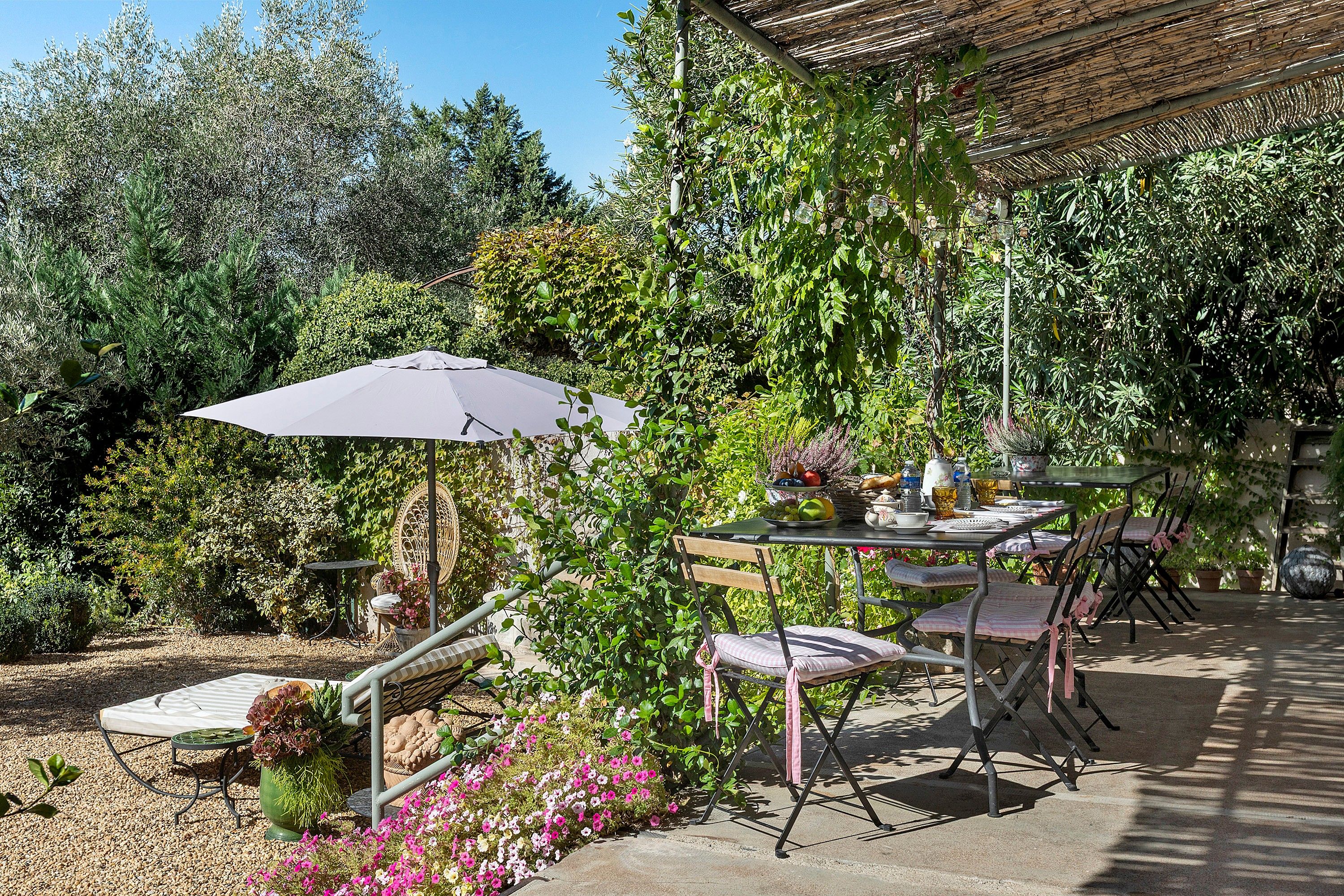 An outdoor patio with a table, chairs, and an umbrella.