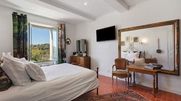 Un dormitorio con una cama, un escritorio, una silla, un televisor y un espejo grande.