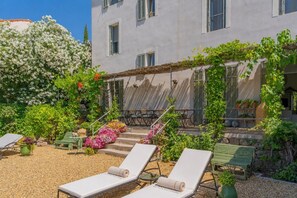A courtyard with outdoor seating, a pergola, and a variety of plants. - Bed and Breakfast 'Chambre 4' with Shared Pool, Wi-Fi and Air Conditioning (La Motte)