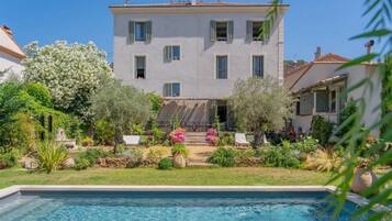 Un edificio di due piani con una piscina in primo piano.