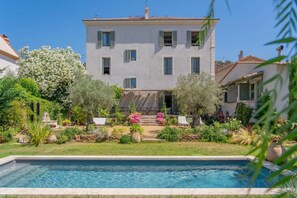 Un bâtiment à deux étages avec une piscine en premier plan.