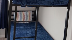 En køjeseng med blå madras og en stige.