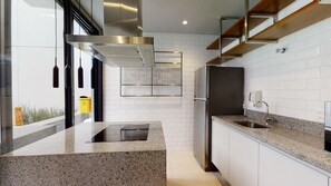 A modern kitchen with a granite countertop, stainless steel appliances, and a white brick backsplash. - VN Higienópolis, 450 meters from the Santa Cecília Metro Station (São Paulo)