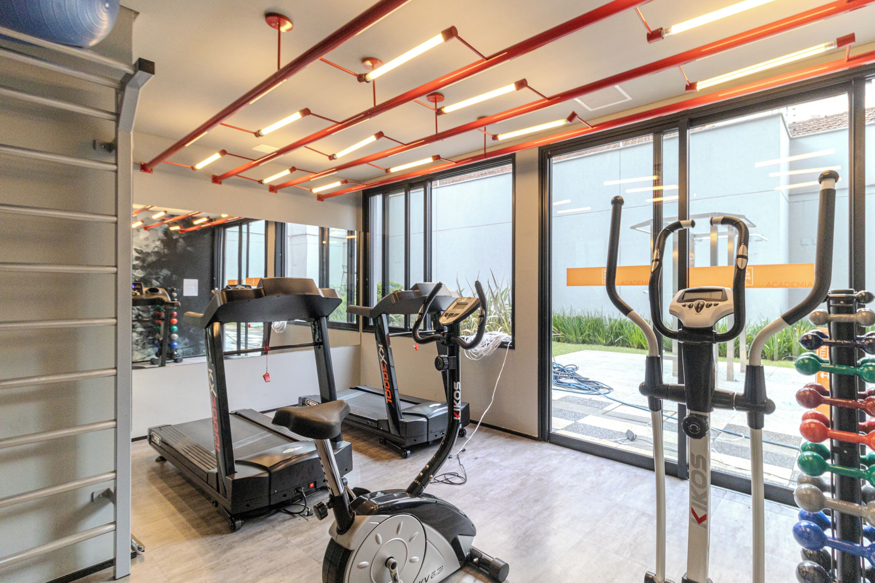 Une salle de sport équipée de matériel d’exercice, d’un tapis de course et d’un vélo d’appartement.