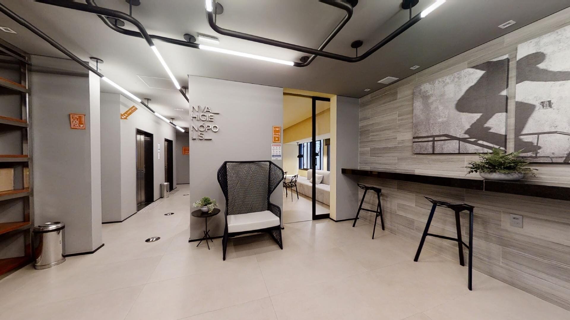 Ein modernes Interieur mit einer Rezeption, einer Sitzecke und Blick in einen weiteren Raum.