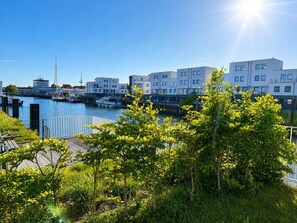 Ein Yachthafen mit modernen Gebäuden, einer Anlegestelle und üppigem Grün.