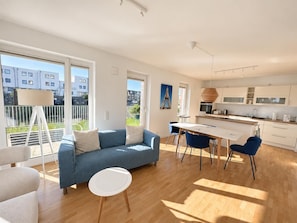 Eine moderne Wohnung mit Wohnbereich, Essbereich und Küche.