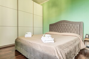 Ein Hotelzimmer mit einem Bett, einer grünen Wand und einem Holzboden.