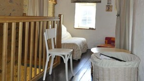 A room with a wooden bunk bed, a white chair, a wicker basket, and a small window. - Gite proche Puy duFou (La Boissière-de-Montaigu)