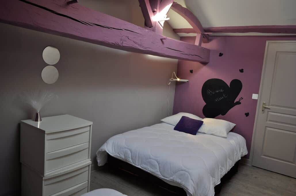 Un dormitorio con cama, cómoda, luz empotrada y una puerta.