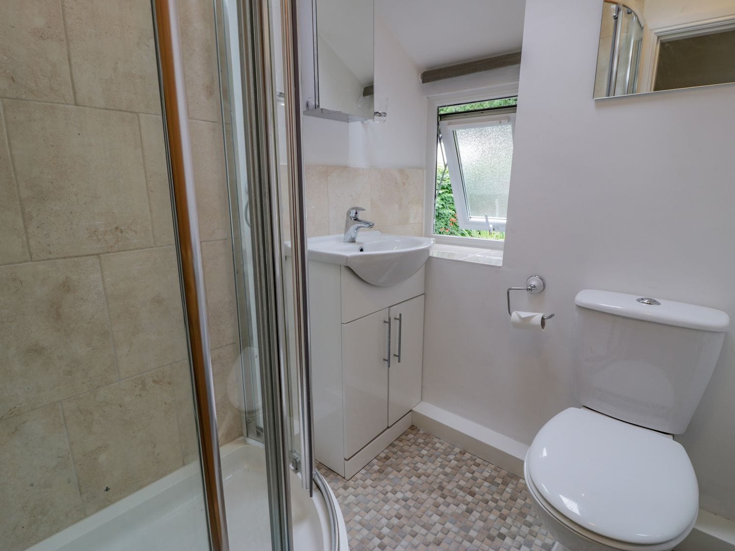 Une salle de bain avec une douche, un lavabo, des toilettes et une fenêtre.
