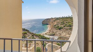 Un balcón con vistas a un paisaje costero, que incluye un acantilado y el mar.
