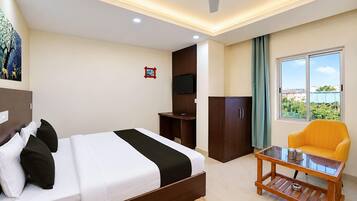 A hotel room with a bed, a television, a desk, a chair, and a window with a view.