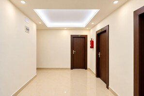 A hallway with a skylight, a fire extinguisher, and a door marked with the number 302.