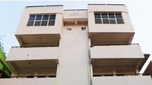 Un edificio de varios pisos con un núcleo central, balcones en cada planta y un techo plano.