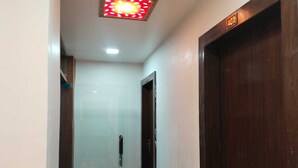 Un pasillo con una puerta de madera identificada con el número 402 y piso de baldosas.