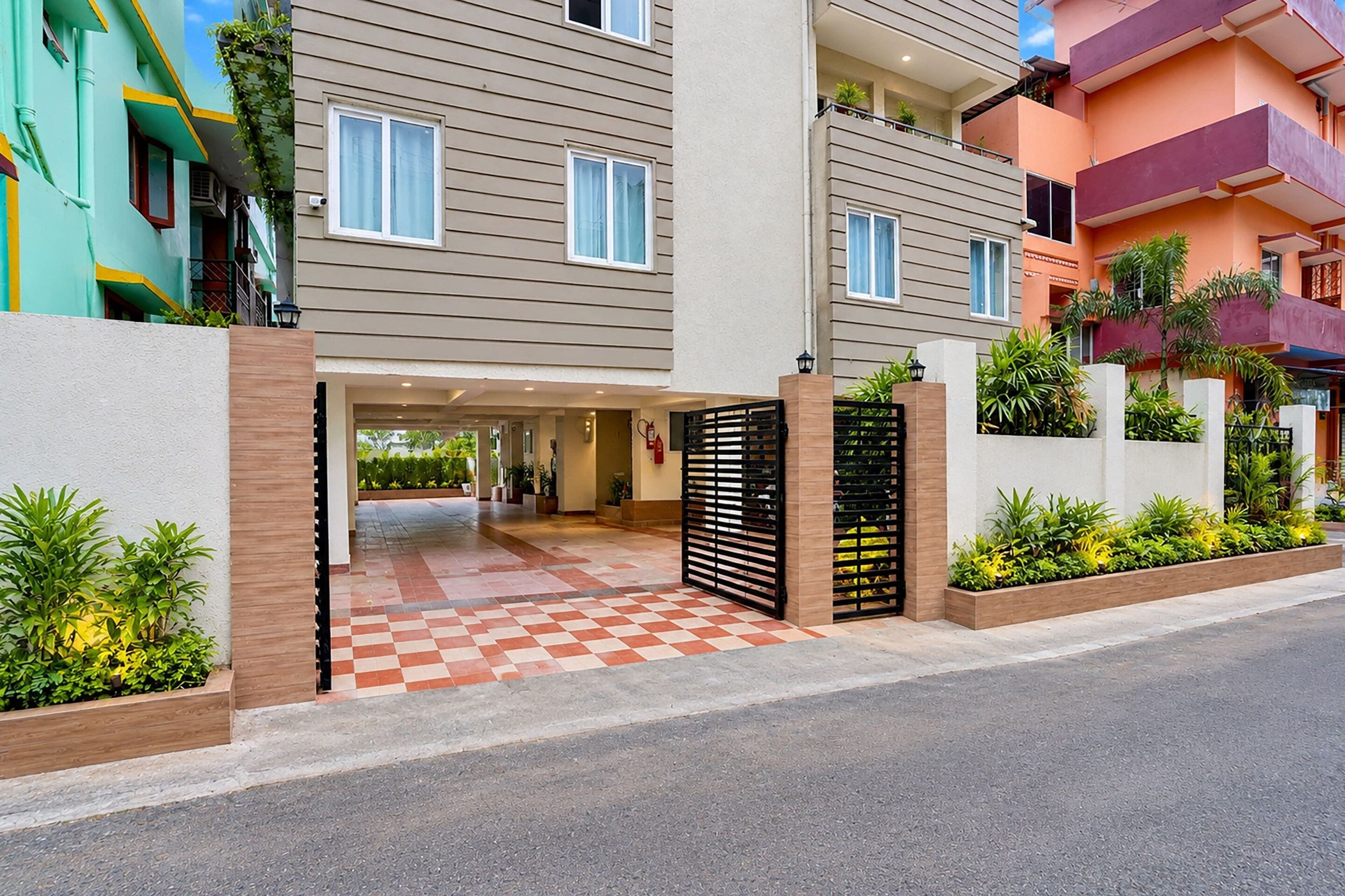 L’entrée d’un hôtel avec un sol à carreaux, une grille et un chemin menant au bâtiment.