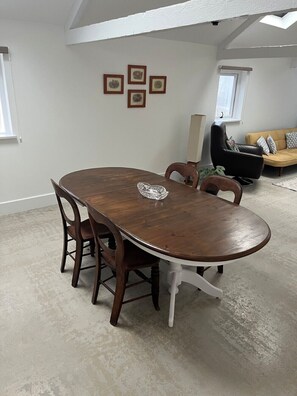 A dining area with a wooden table, chairs, and a ceiling skylight. - Newly completed barn conversion in picturesque village of Sidbury. (PQ9H+949 Sidmouth)
