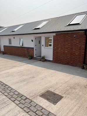 A single-story building with a brick facade and a white exterior. - Newly completed barn conversion in picturesque village of Sidbury. (PQ9H+949 Sidmouth)