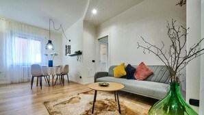 Un soggiorno moderno con un divano, un tavolino da caffè e un'area pranzo con sedie e un tavolo.