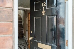 A black door with the number 12, a brass knocker, and a keyhole. - Calming Boutique Design House - Walk to City (Clifton)