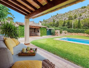 A patio with outdoor furniture, a pool, and a view of a hillside. - Family Villa Between Pollenca Towns (Pollença)
