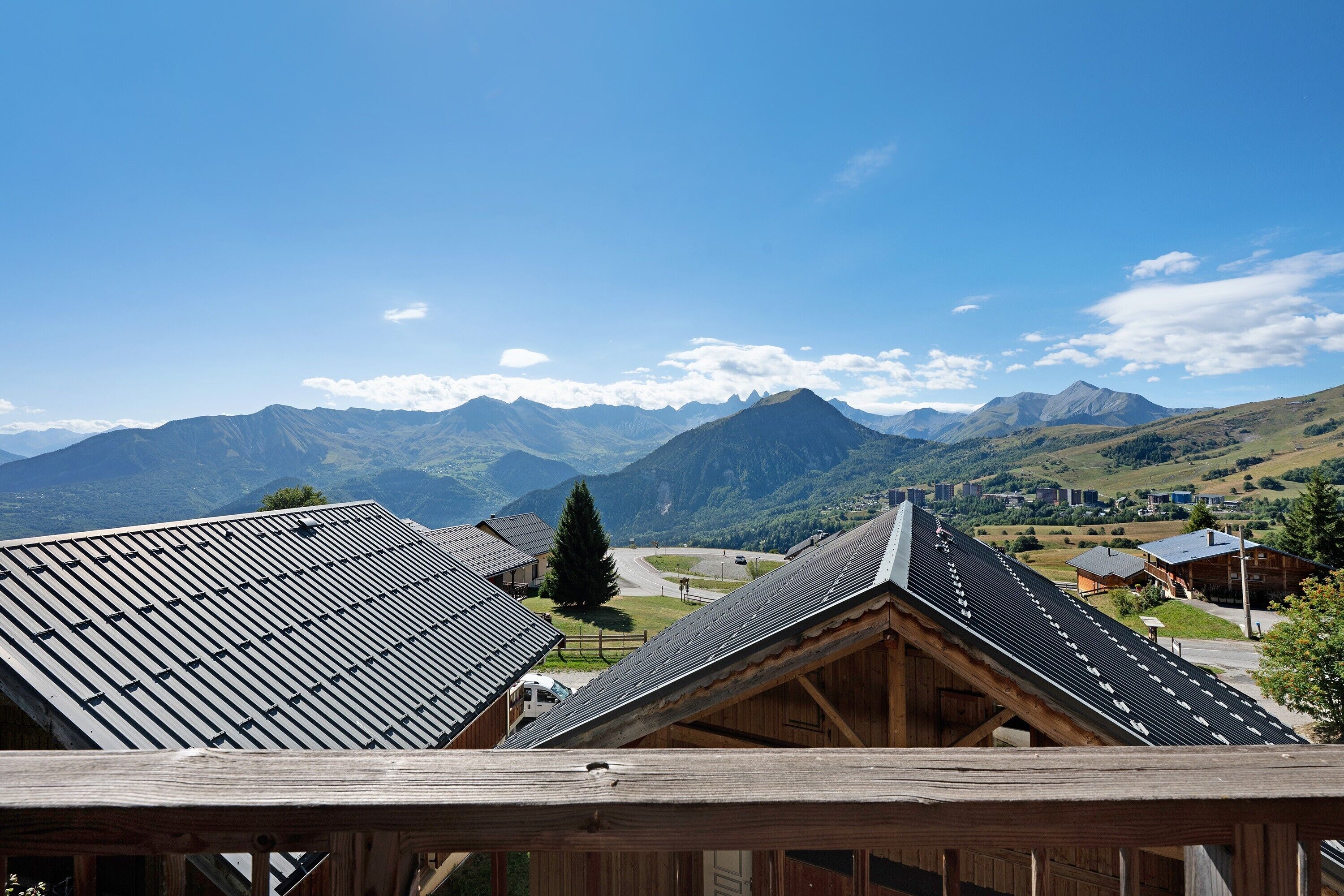 A mountain village with traditional wooden houses and a clear view of the surrounding peaks.
