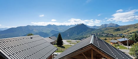 A mountain village with traditional wooden houses and a clear view of the surrounding peaks.