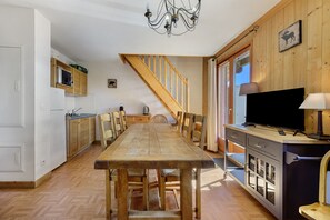 Eine geräumige Küche mit Holzausstattung, einem Esstisch und Stühlen.