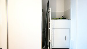 A compact kitchenette with a refrigerator, a small sink, and a stove. - Ultimate Comfort - Modern 3BR Apt with Pool and Gy (Adelaide)