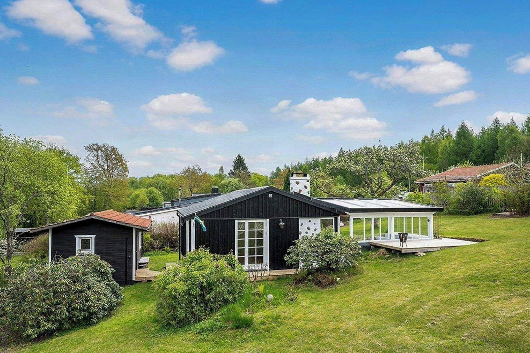 A residential property with a main house, a smaller shed, and a covered outdoor area.