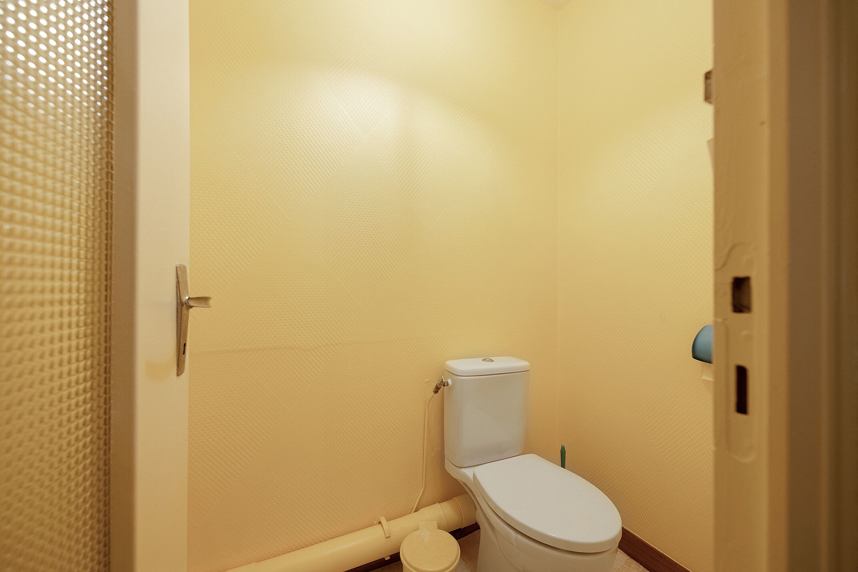 Een kleine badkamer voor één persoon met toilet, wastafel en douche.