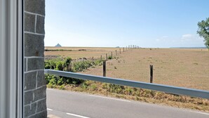 Vista dalla finestra su un campo recintato sotto un cielo sereno.